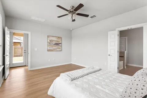 a kitchen with stainless steel appliances kitchen island granite countertop a sink a stove a dining table and chairs with wooden floor