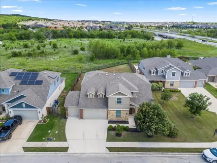 an aerial view of residential houses with outdoor space and parking