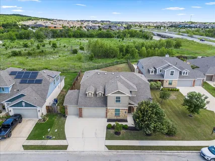 an aerial view of residential houses with outdoor space and parking