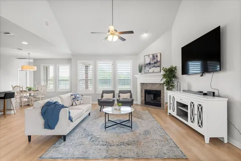 a living room with furniture a fireplace and a flat screen tv