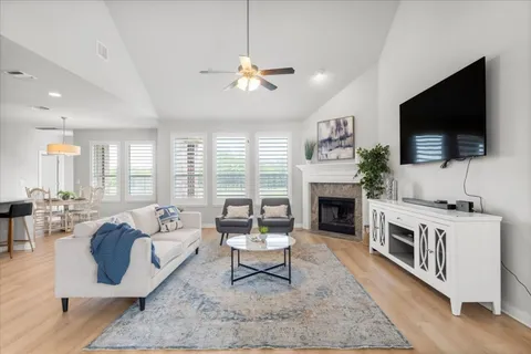 a living room with furniture a fireplace and a flat screen tv