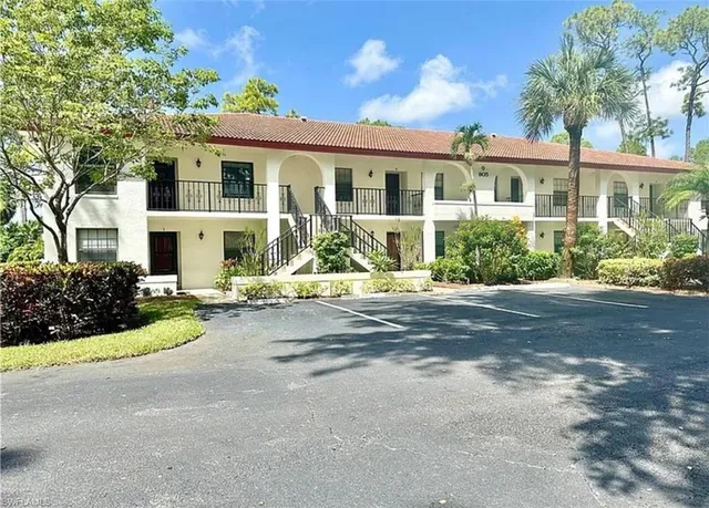 a front view of a house with a yard and potted plants