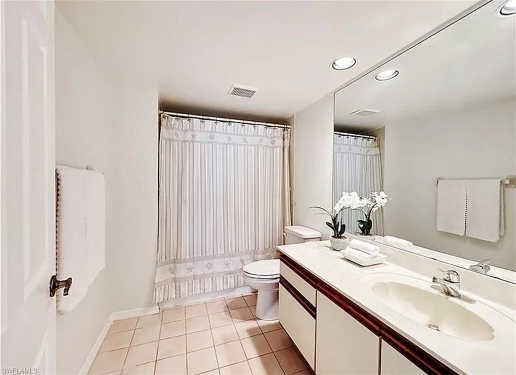 905 Augusta Boulevard Naples, FL 34113 - Photo 12 of 20 a bathroom with a double vanity sink toilet and a mirror