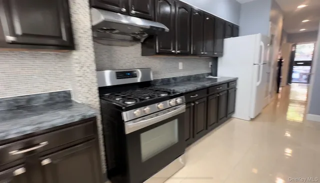 a kitchen with stainless steel appliances granite countertop a stove and a refrigerator