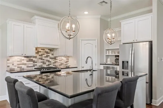 a kitchen with stainless steel appliances granite countertop a sink and a refrigerator