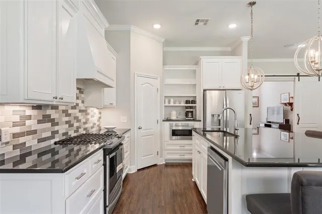 a kitchen with stainless steel appliances a refrigerator sink and stove