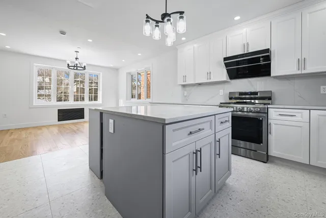 a kitchen with kitchen island white cabinets and window