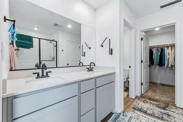 a bathroom with a sink double vanity and a toilet