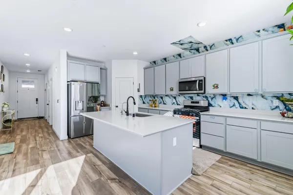a kitchen with white cabinets and stainless steel appliances