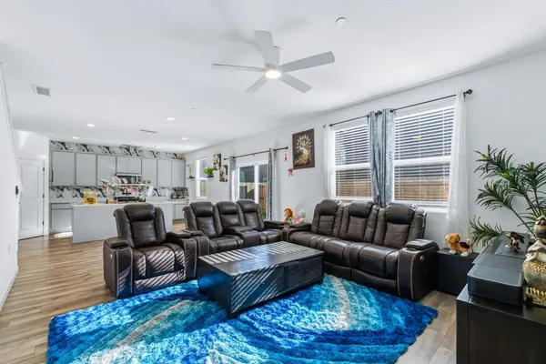 a living room with furniture wooden floor and a large window