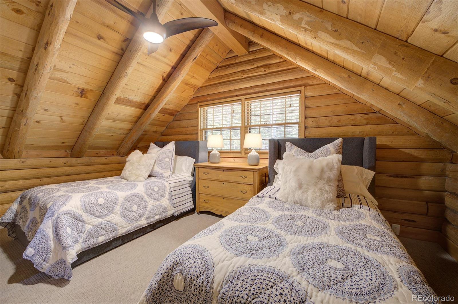 9670 South Warhawk Road Conifer, CO 80433 - Photo 29 of 40 a bed sitting in a bedroom next to a window