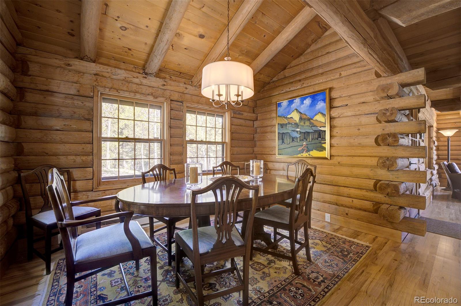 9670 South Warhawk Road Conifer, CO 80433 - Photo 10 of 40 a view of a dining room with furniture a chandelier and wooden floor
