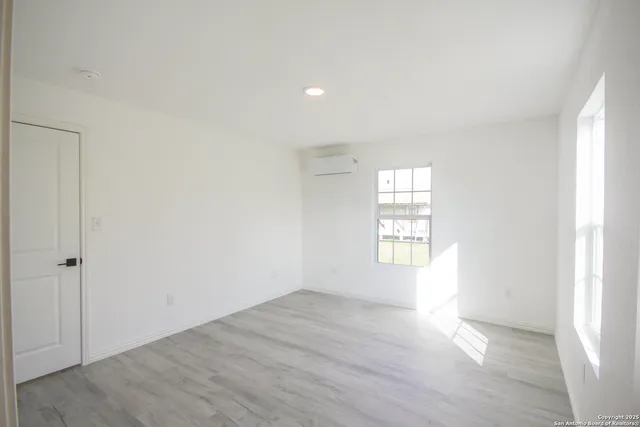 an empty room with wooden floor and window