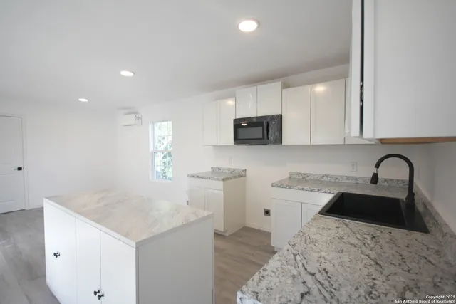 a kitchen with a sink a stove a microwave and cabinets