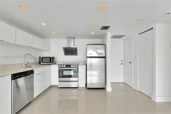 a kitchen with cabinets and stainless steel appliances