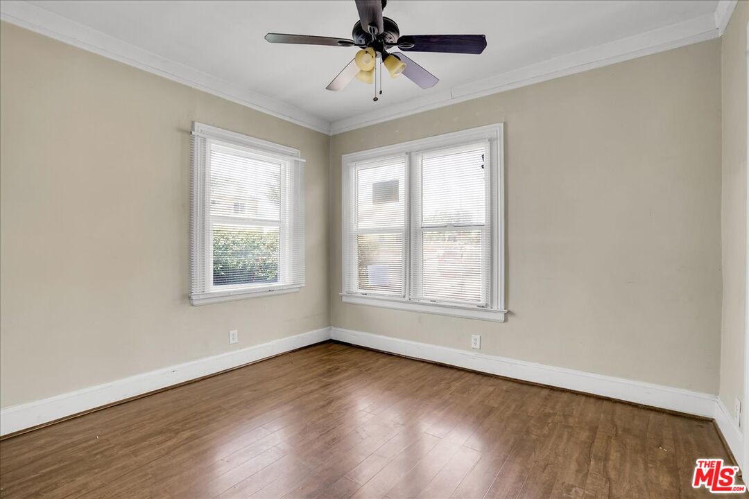 1221 West 152nd Street Compton, CA 90220 - Photo 13 of 20 an empty room with wooden floor chandelier fan and windows