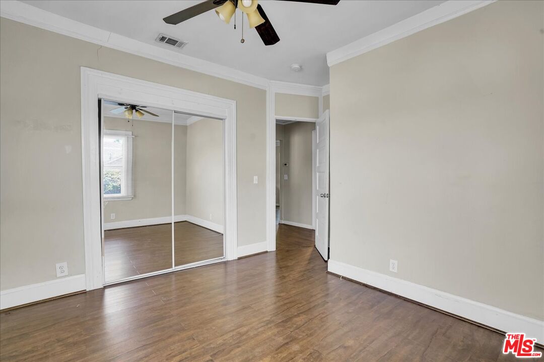 1221 West 152nd Street Compton, CA 90220 - Photo 14 of 20 an empty room with wooden floor cabinet and windows