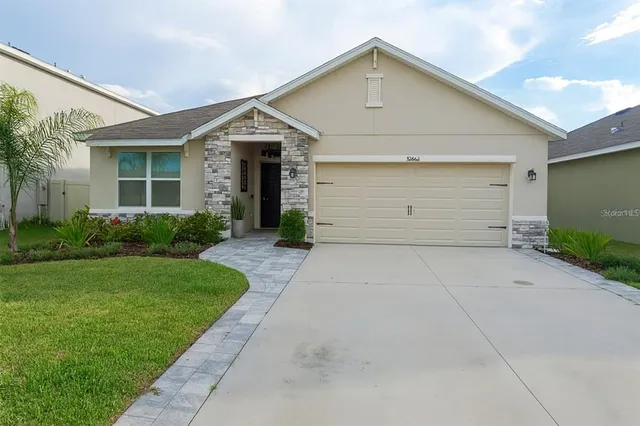 a front view of a house with a yard and garage