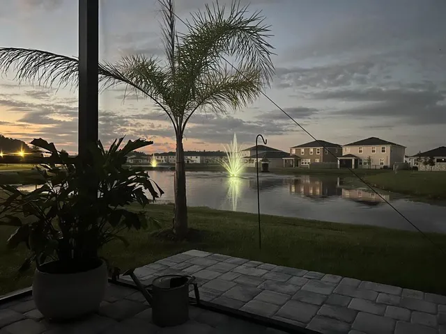 a kitchen with kitchen island granite countertop stainless steel appliances a sink a stove a refrigerator a center island and chairs