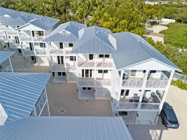an aerial view of a house with wooden deck and furniture