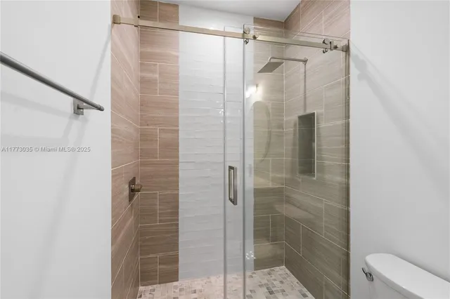 a white toilet sitting next to a white wall