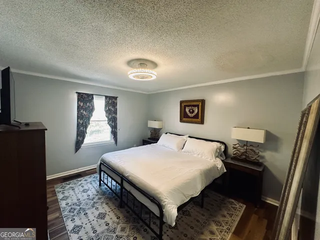 a bedroom with a bed and a mirror on dresser