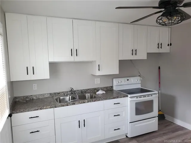 a kitchen with white cabinets and white appliances