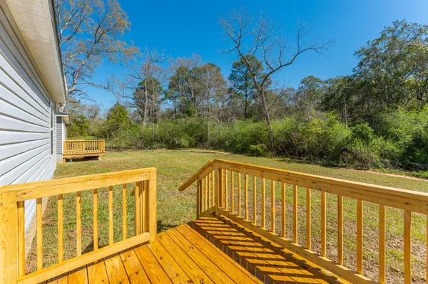 a view of a balcony with wooden floor and fence