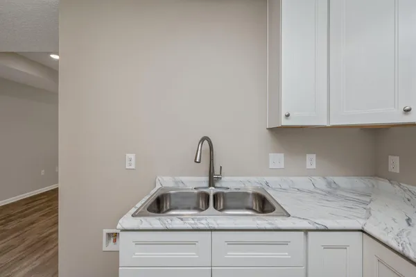 a kitchen with granite countertop white cabinets and a sink