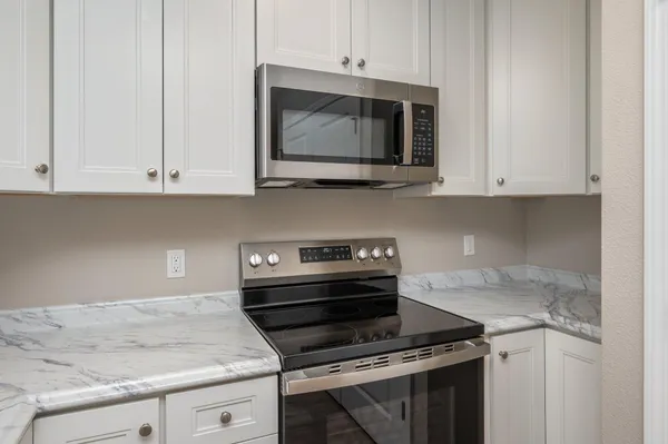 a kitchen with granite countertop a stove and a microwave