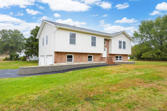 a view of a house with a yard and a tree