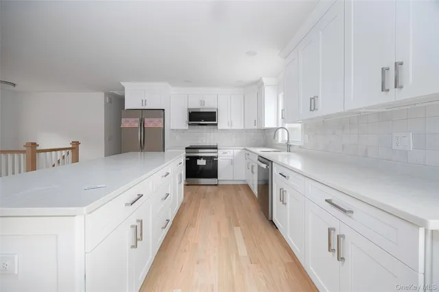 a large kitchen with cabinets and stainless steel appliances