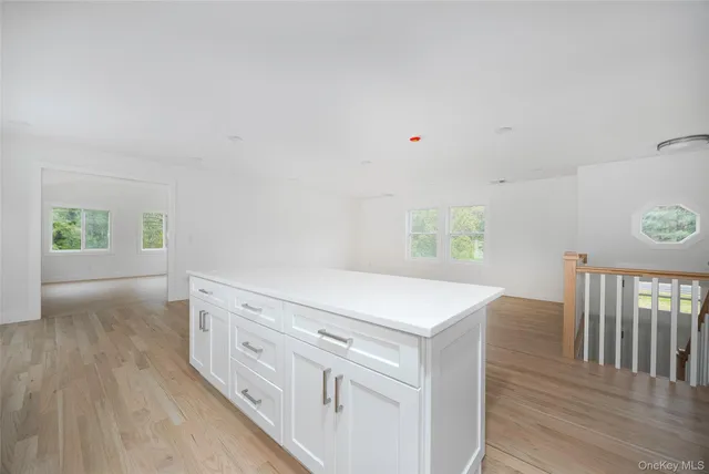 a kitchen with white cabinets and wooden floor
