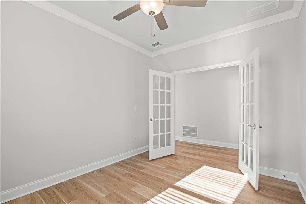 248 Nesta Grove Locust Grove, GA 30248 - Photo 8 of 40 a view of an empty room with wooden floor and a ceiling fan