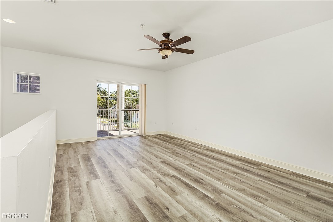 2110 West First Street, Unit 103 Fort Myers, FL 33901 - Photo 13 of 38 an empty room with wooden floor fan and windows