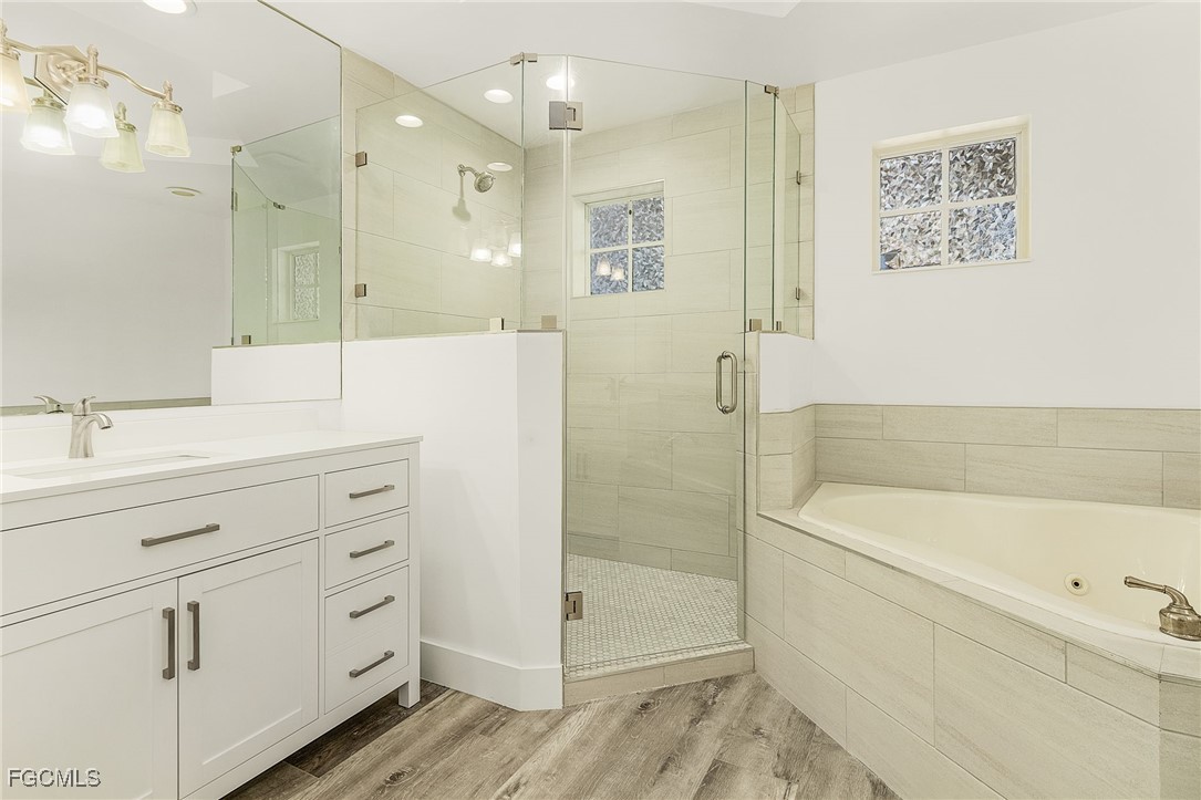 2110 West First Street, Unit 103 Fort Myers, FL 33901 - Photo 21 of 38 a bathroom with a bathtub shower sink vanity and mirror