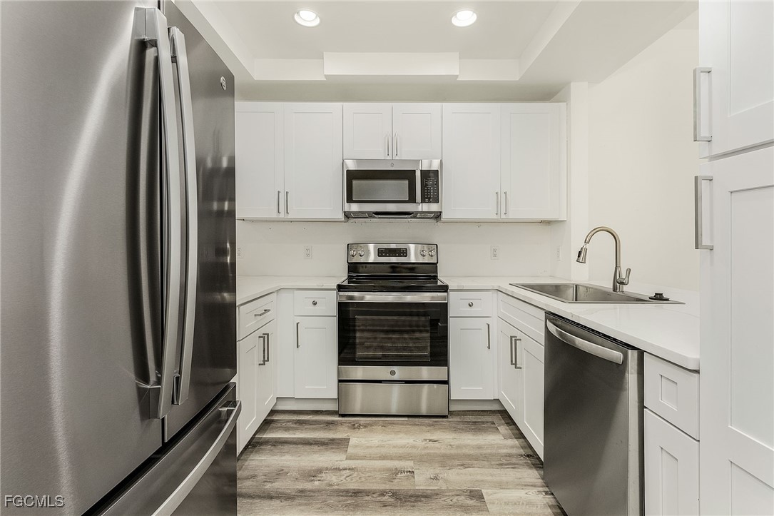 2110 West First Street, Unit 103 Fort Myers, FL 33901 - Photo 8 of 38 a kitchen with a sink stove and refrigerator