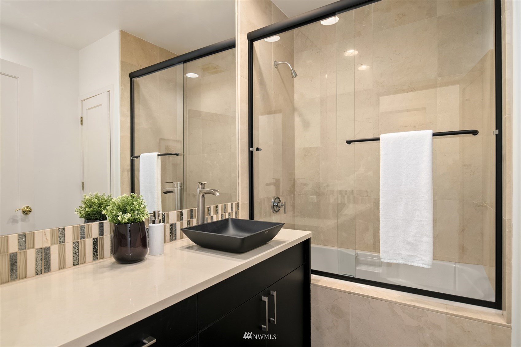 3768 West Commodore Way Seattle, WA 98199 - Photo 23 of 37 a bathroom with a sink a large mirror and a shower