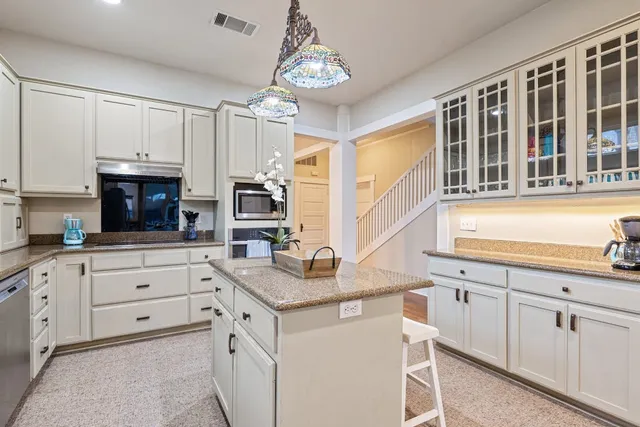 a kitchen with granite countertop white cabinets and white appliances