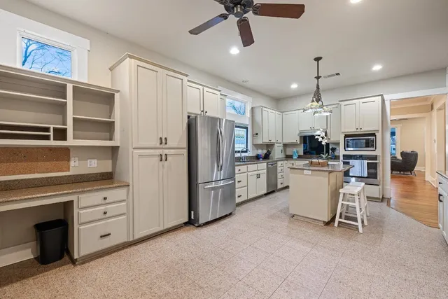 a kitchen with white cabinets and stainless steel appliances