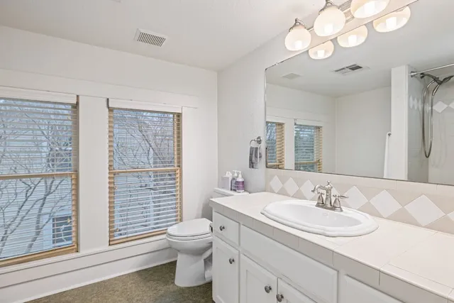 a bathroom with a sink vanity granite and toilet