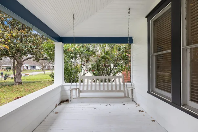 a view of a porch with a floor to ceiling window and a yard