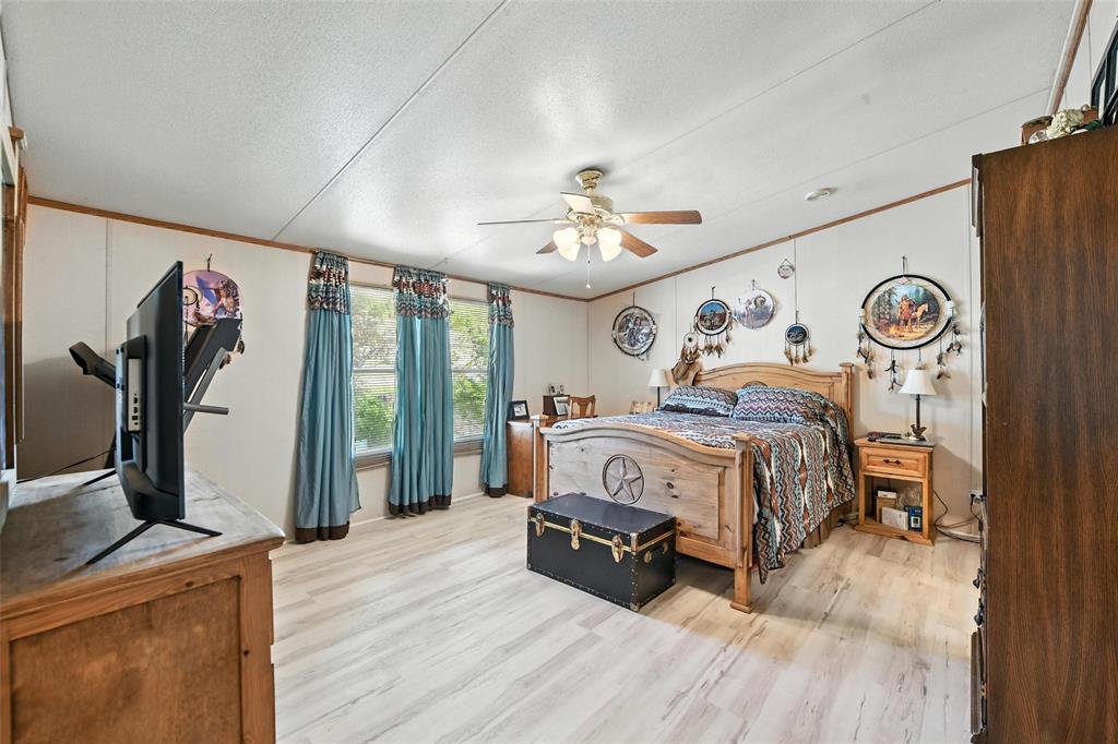 1933 Carter Road Springtown, TX 76082 - Photo 15 of 38 Bedroom with light wood-style floors, ornamental molding, ceiling fan, and a textured ceiling