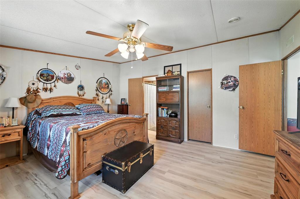 1933 Carter Road Springtown, TX 76082 - Photo 16 of 38 Bedroom featuring light wood-type flooring, crown molding, and a ceiling fan