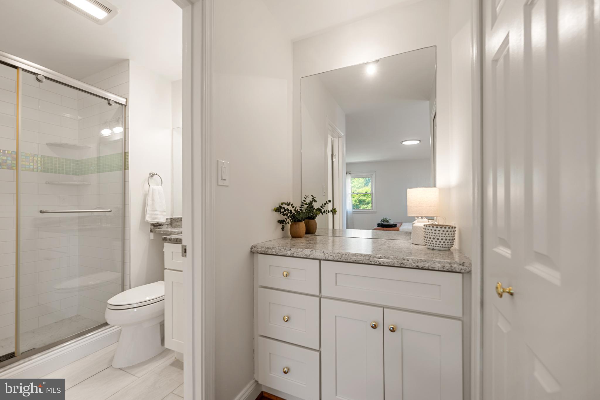 6800 Seton Court Springfield, VA 22152 - Photo 21 of 51 a bathroom with a granite countertop sink a toilet and shower