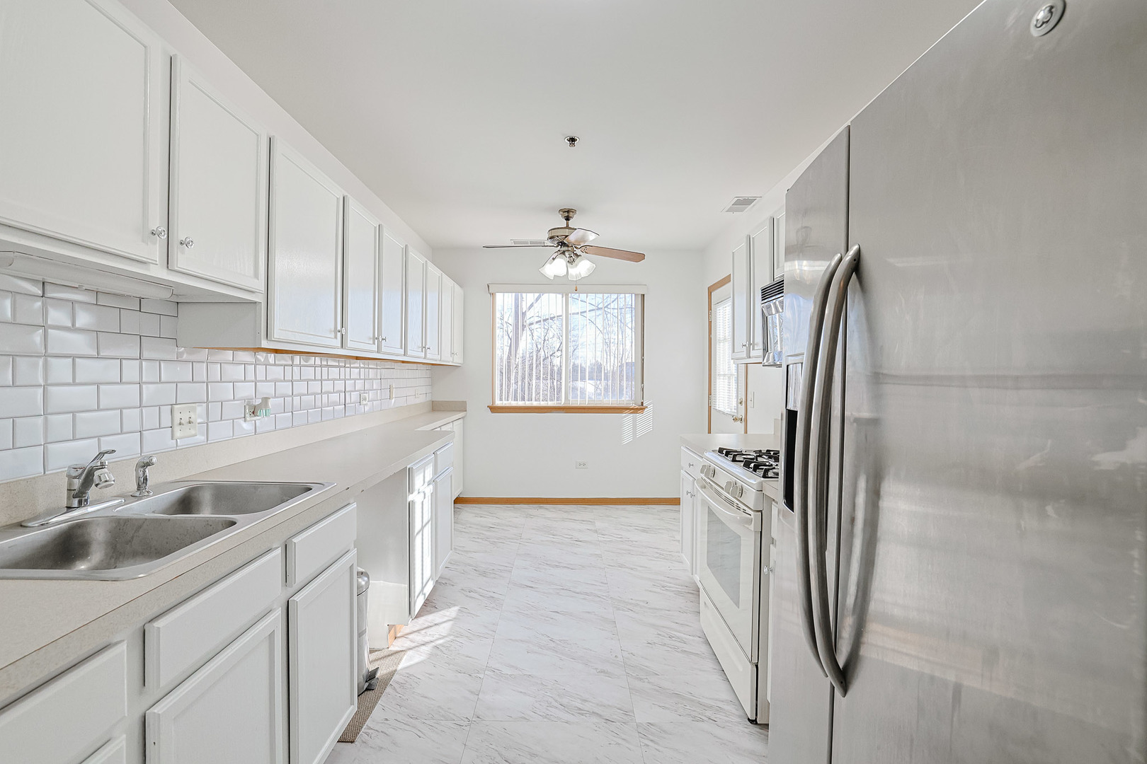 881 North Swift Road, Unit 206 Addison, IL 60101 - Photo 11 of 26 a kitchen with a sink and refrigerator