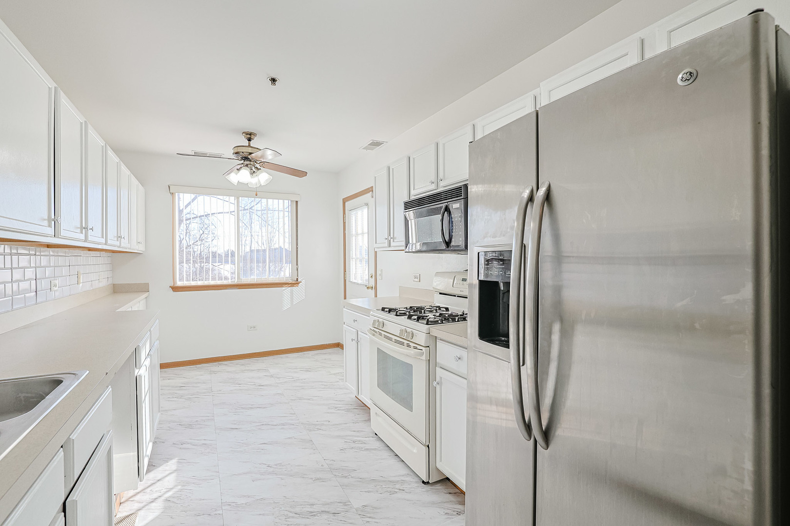 881 North Swift Road, Unit 206 Addison, IL 60101 - Photo 13 of 26 a kitchen with white cabinets and stainless steel appliances