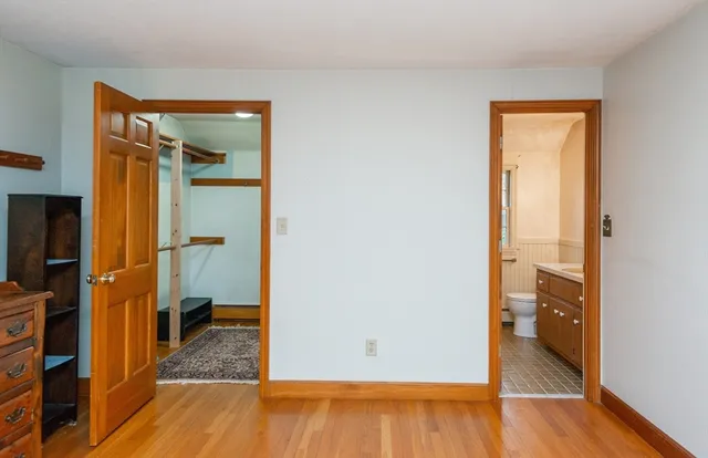a view of walk in closet with window and wooden floor