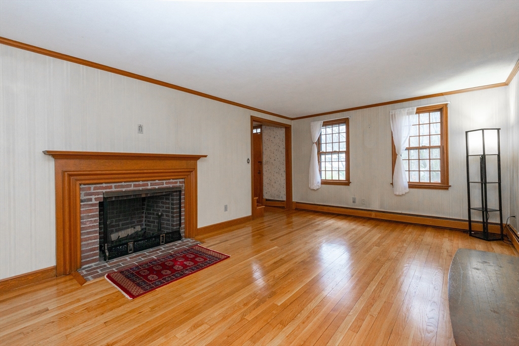 15 Hart Road Lynnfield, MA 01940 - Photo 5 of 40 a view of an empty room with wooden floor fireplace and a window
