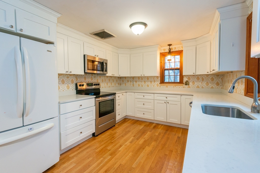 15 Hart Road Lynnfield, MA 01940 - Photo 8 of 40 a kitchen with white cabinets and white appliances